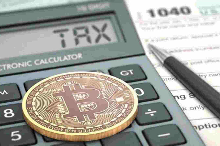 Bitcoin coin on calculator with tax form and pen.